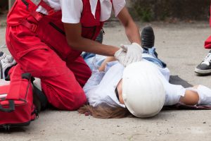 worker giving first aid to another worker